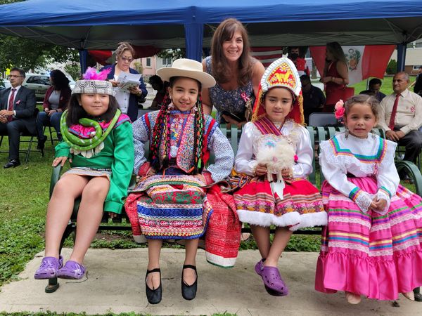 Food Brigade President Karen DeMarco with children in traditional Peruvian dress