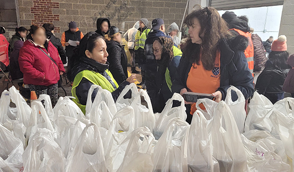 Food Brigade President Karen DeMarco instructs volunteers for the hot meal distribution operation at the Union City food pantry location